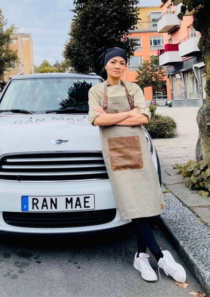 Arrangören står framför en vit bil.