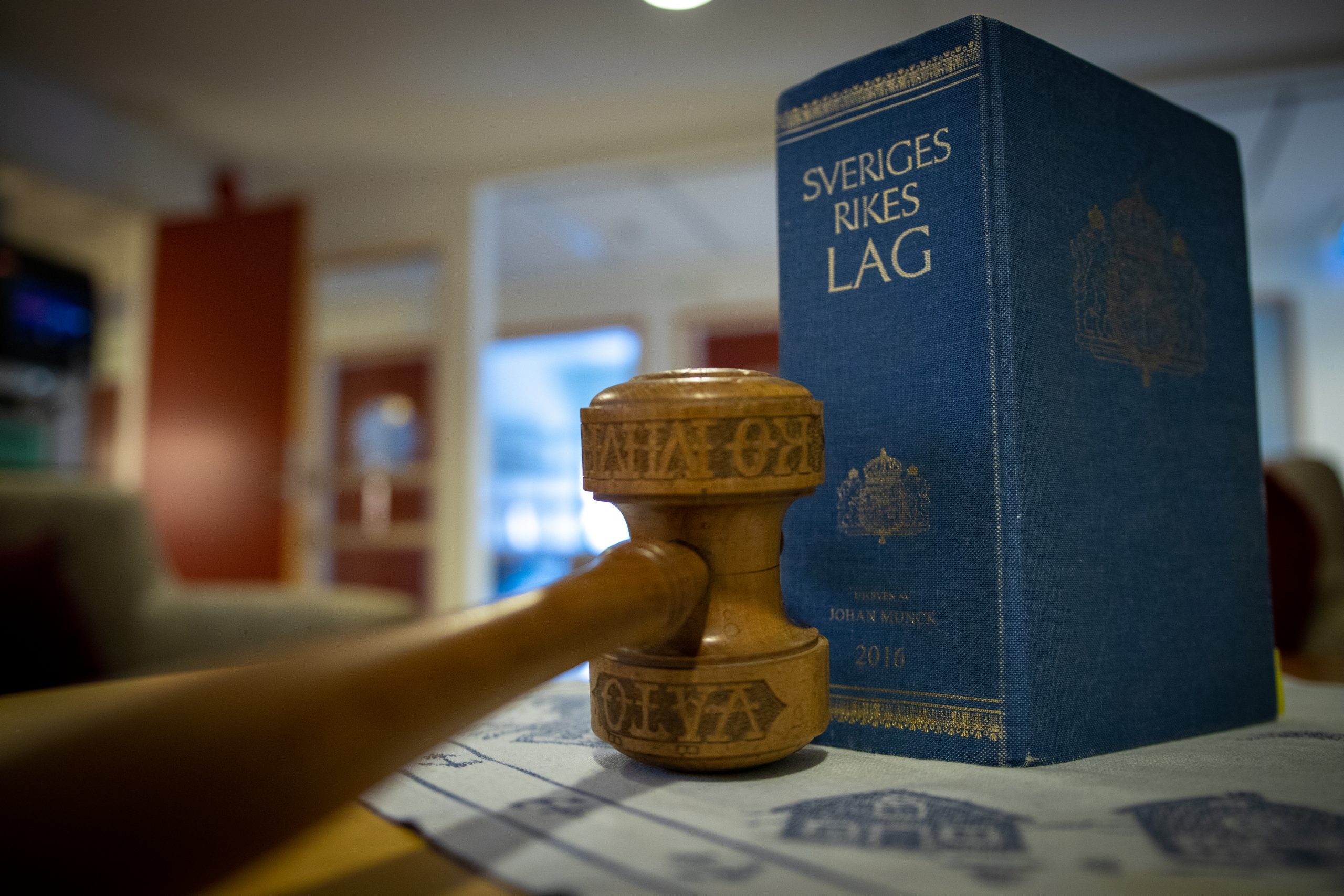Bild på en hammare och Sveriges rikes lag.