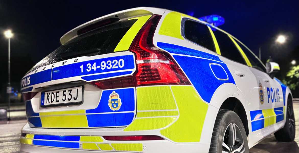 En stillastående polisbil i kvällsmörker