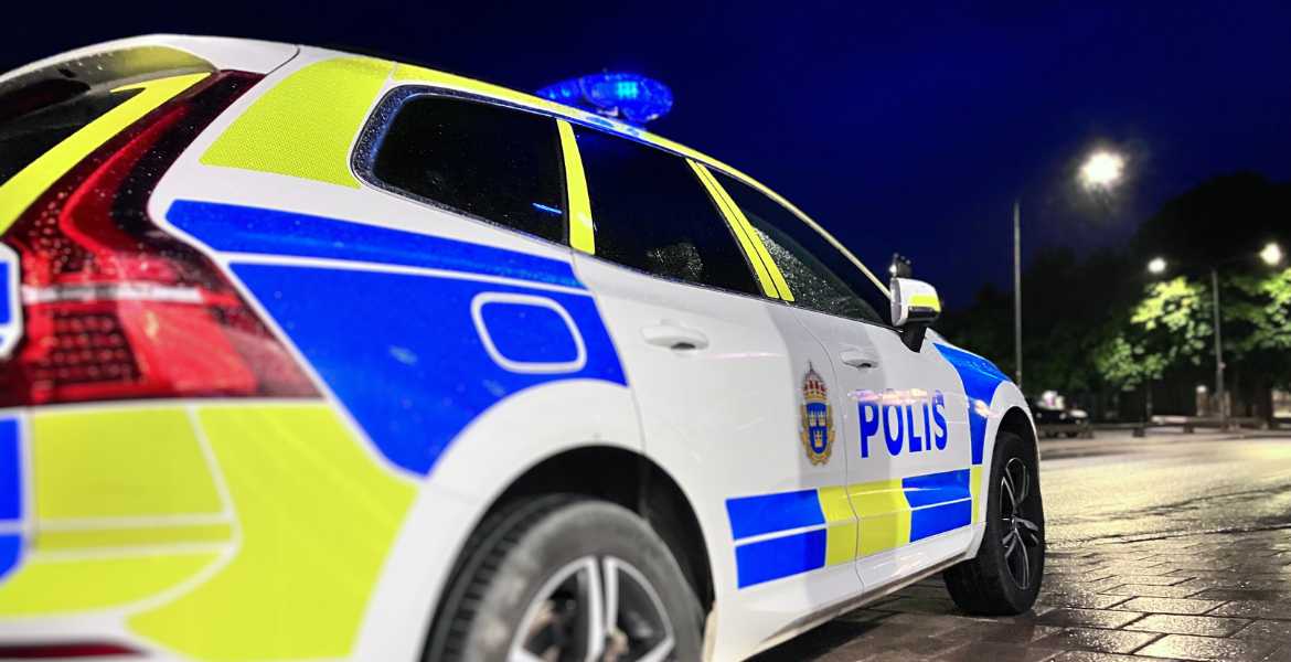 En stillastående polisbil i mörker.