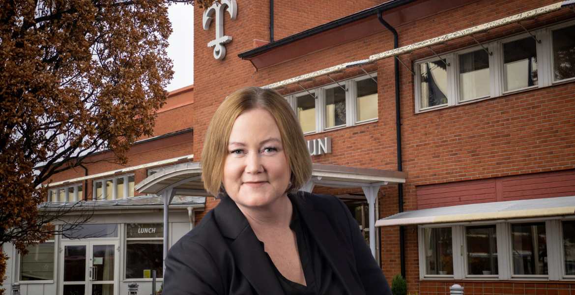 Ulrika Falk framför Norrtäljes kommunhus i dagsljus.