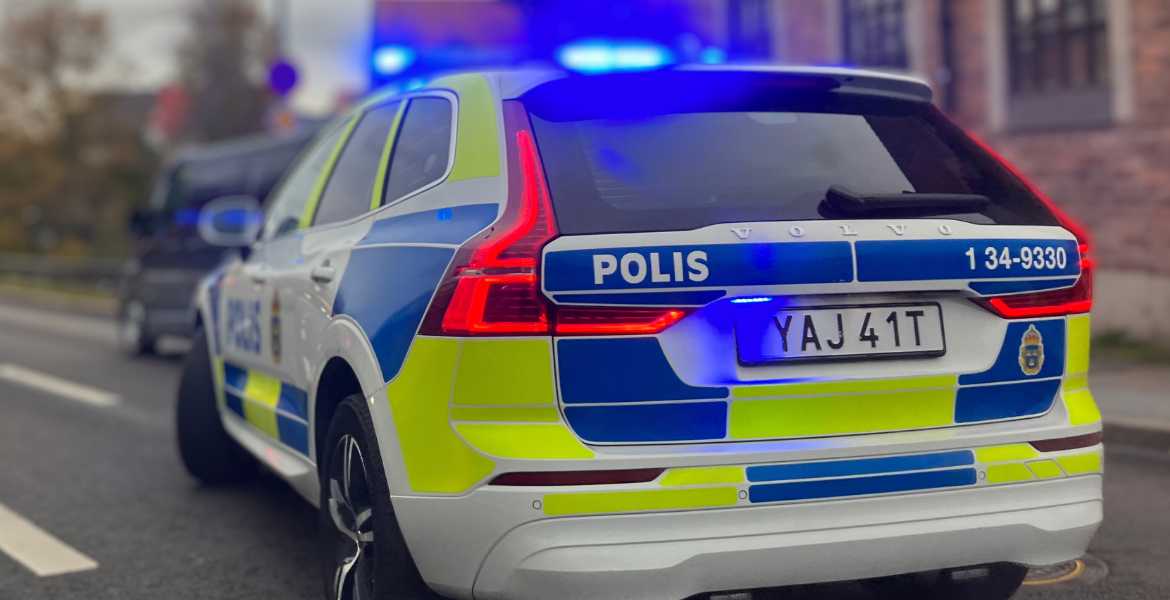 En polisbil i rörelse med blåljus.