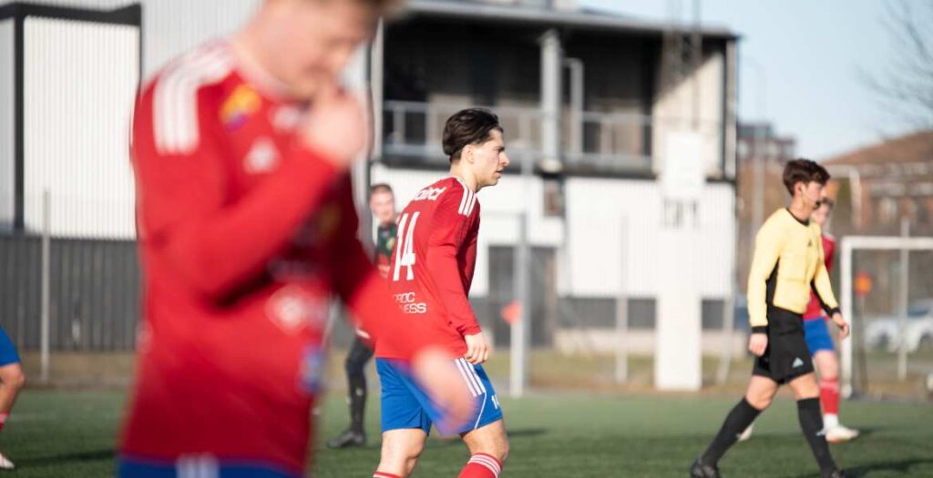 Fotbollsspelare i fart under en match i dagsljus.