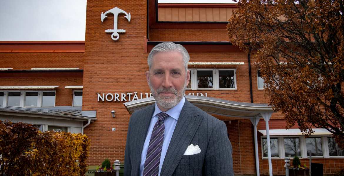 Rickard Sundbom, ny kommundirektör i Norrtälje framför Norrtäljes kommunhus i dagsljus.