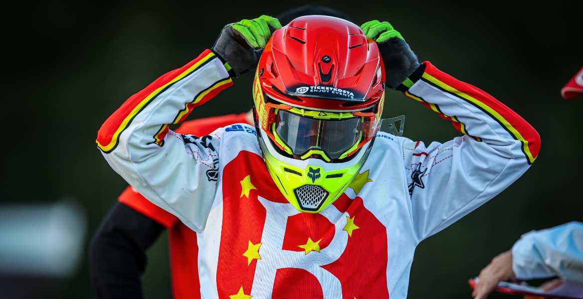 En speedwayförare som sätter på sig masken.