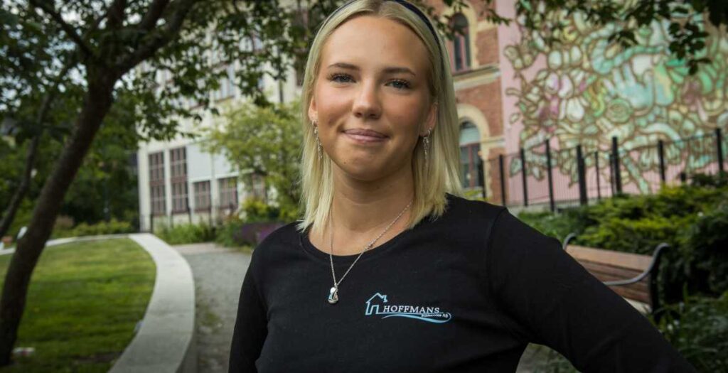 Entreprenören Amanda Hoffman framför Norrtäljes enda muralmålning, i dagsljus.